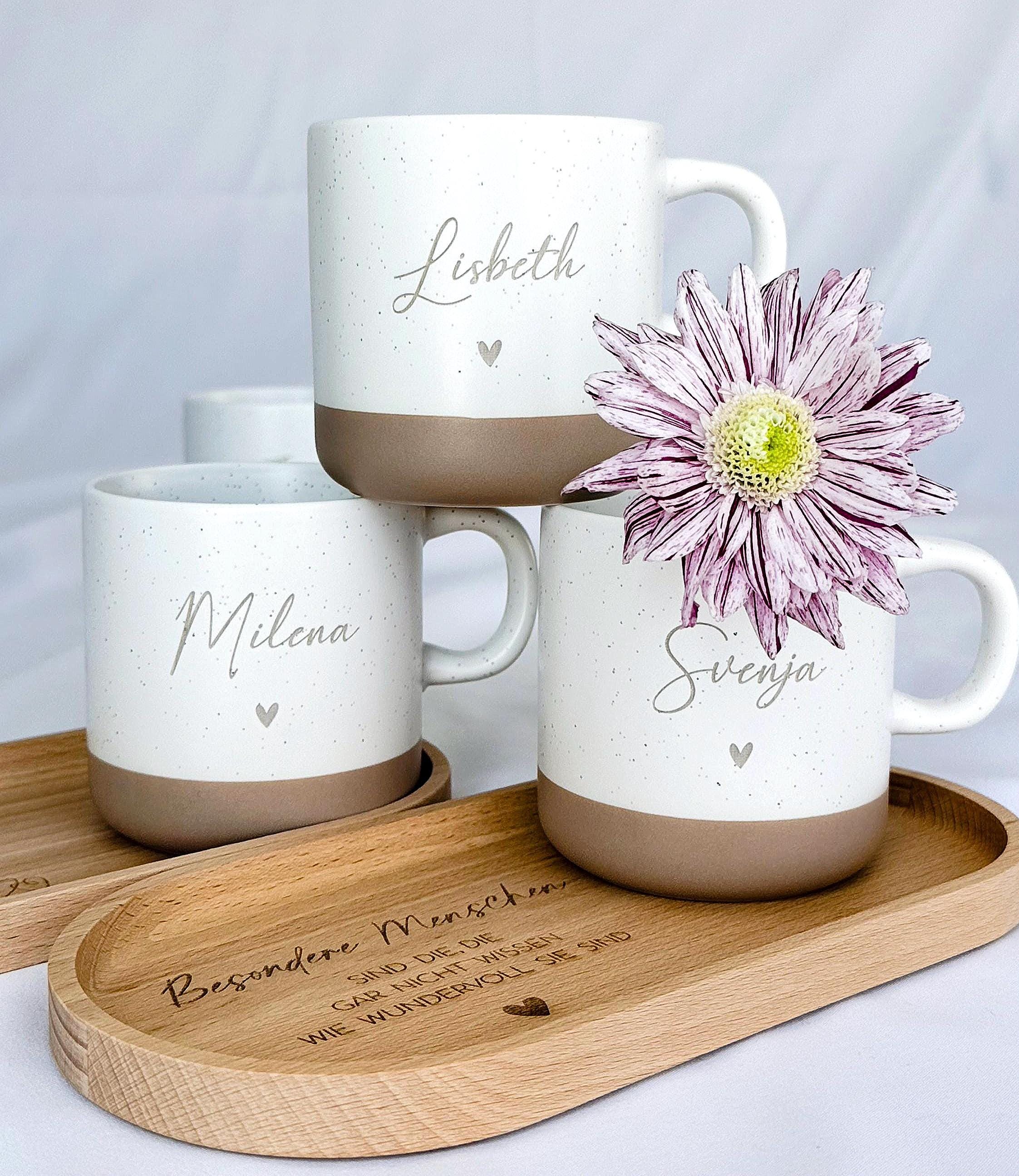 "Keramiktasse mit personalisierter Namensgravur, befüllt mit Kaffee – auf Tablett serviert. Beige Tasse mit matter Oberfläche und 360 ml Volumen, perfekt für den Start in den Tag. Geschenk für Kolleg:innen, Freund:innen oder Familie, ideal für Abschied oder als kleine Überraschung. Zeitloses Design, langlebig, spülmaschinengeeignet, liebevoll graviert und dekorativ. steingut tasse