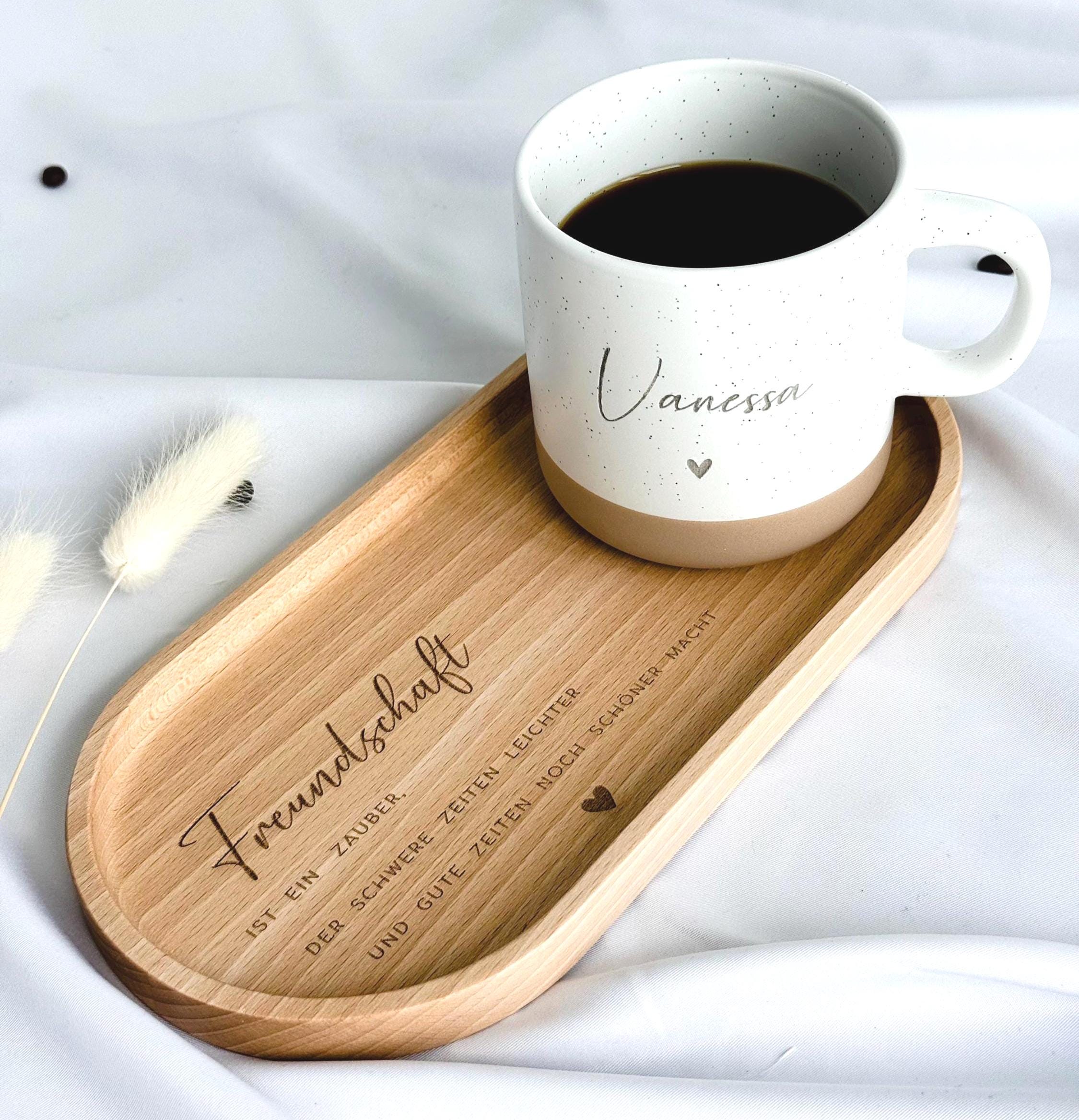 Keramiktasse mit personalisierter Namensgravur, befüllt mit Kaffee – auf Tablett serviert. Beige Tasse mit matter Oberfläche und 360 ml Volumen, perfekt für den Start in den Tag. Geschenk für Kolleg:innen, Freund:innen oder Familie, ideal für Abschied oder als kleine Überraschung. Zeitloses Design, langlebig, spülmaschinengeeignet, liebevoll graviert und dekorativ. Steingut Tasse. Personalisierte Geschenke