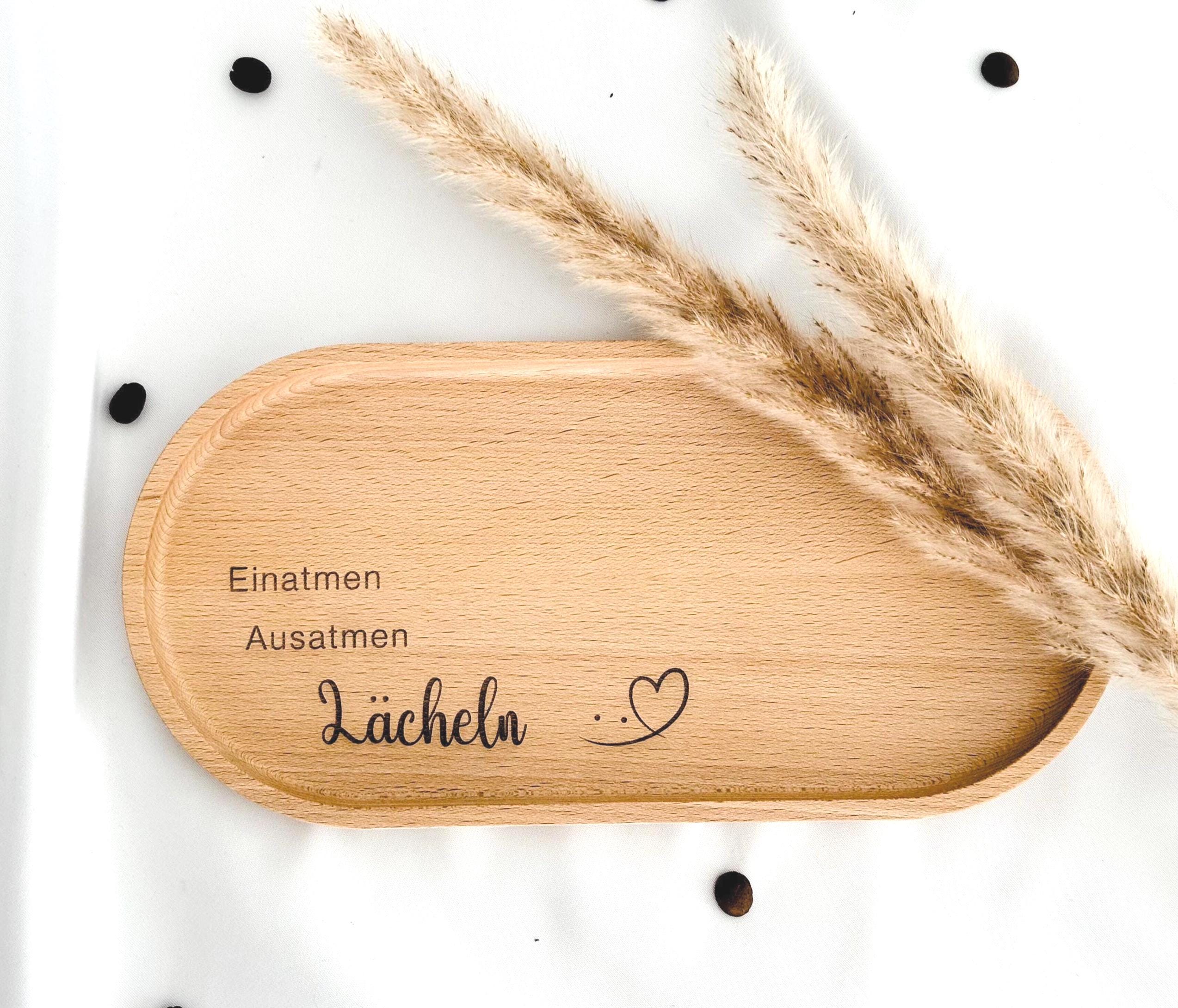 Buchenholz-Tablett in natürlicher Optik, ideal für das Servieren von Snacks oder als Geschenkidee für Mama, Schwester oder Freunde. Mit einer Behandlung aus Hartwachs ist das Tablett langlebig und pflegeleicht, perfekt für den täglichen Gebrauch. Lächeln Holztablett