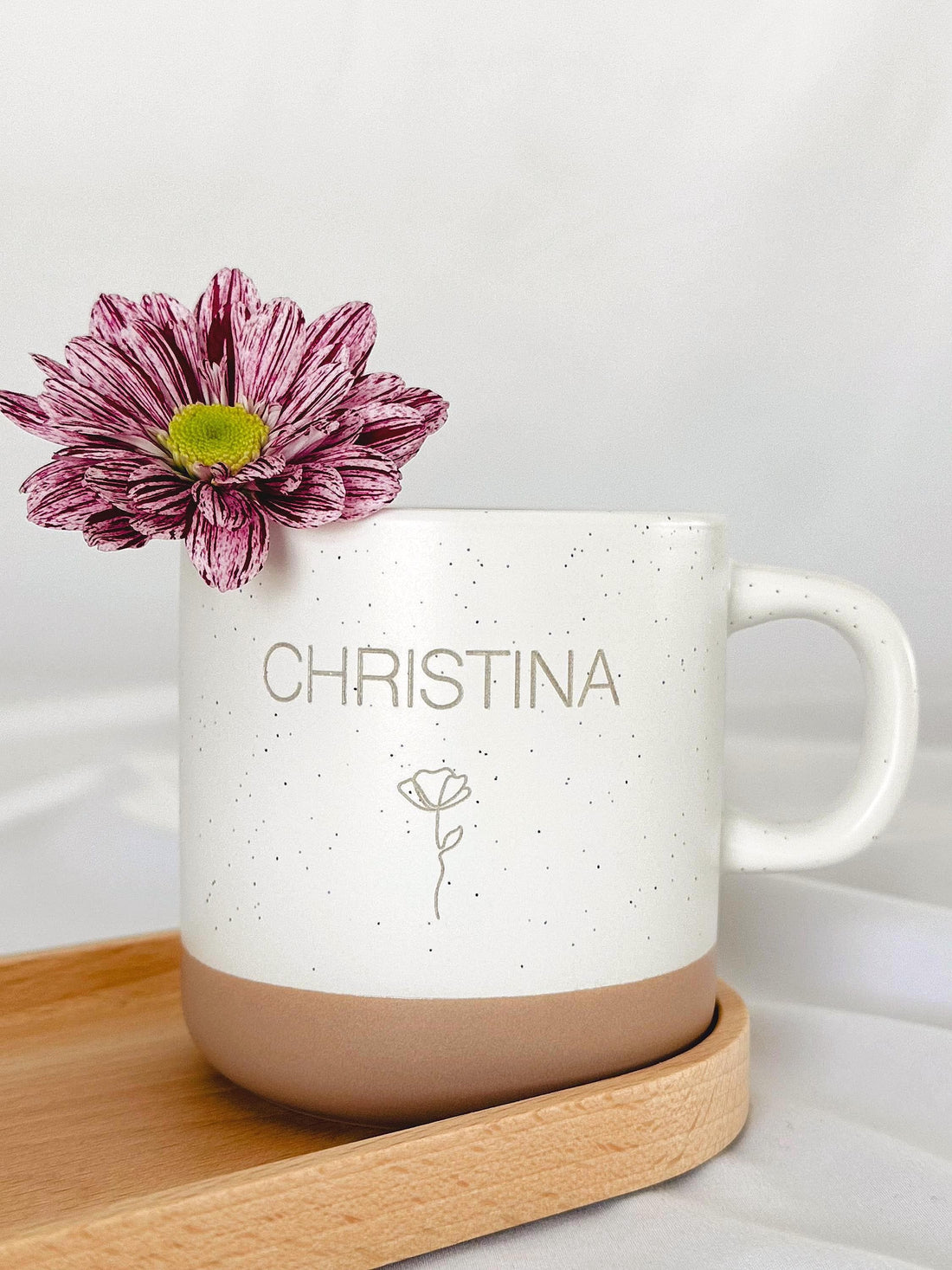 Detailaufnahme der personalisierten Tasse mit individueller Namensgravur. Weiße Keramiktasse mit gesprenkeltem Muster, matter Oberfläche und unglasiertem Boden. Perfekt als Geschenk für Freundin, Kollegin oder als kleine Aufmerksamkeit für besondere Menschen – geeignet für Kaffee, Tee oder heiße Schokolade. Mikrowellen- und spülmaschinenfest. Stilvoll und liebevoll gestaltet. Steingut Tasse beige Personalisierbar