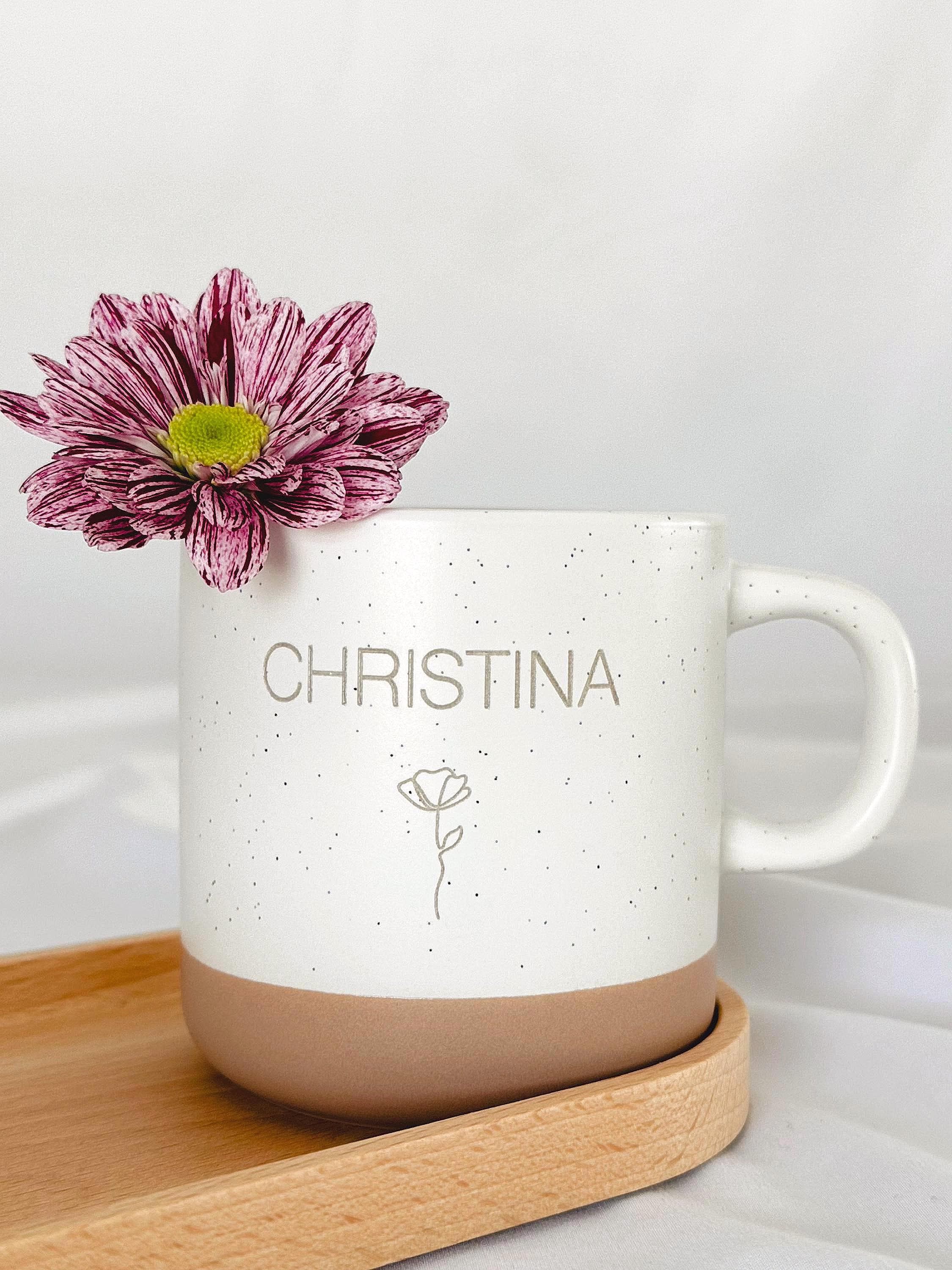 Detailaufnahme der personalisierten Tasse mit individueller Namensgravur. Weiße Keramiktasse mit gesprenkeltem Muster, matter Oberfläche und unglasiertem Boden. Perfekt als Geschenk für Freundin, Kollegin oder als kleine Aufmerksamkeit für besondere Menschen – geeignet für Kaffee, Tee oder heiße Schokolade. Mikrowellen- und spülmaschinenfest. Stilvoll und liebevoll gestaltet. Steingut Tasse beige Personalisierbar