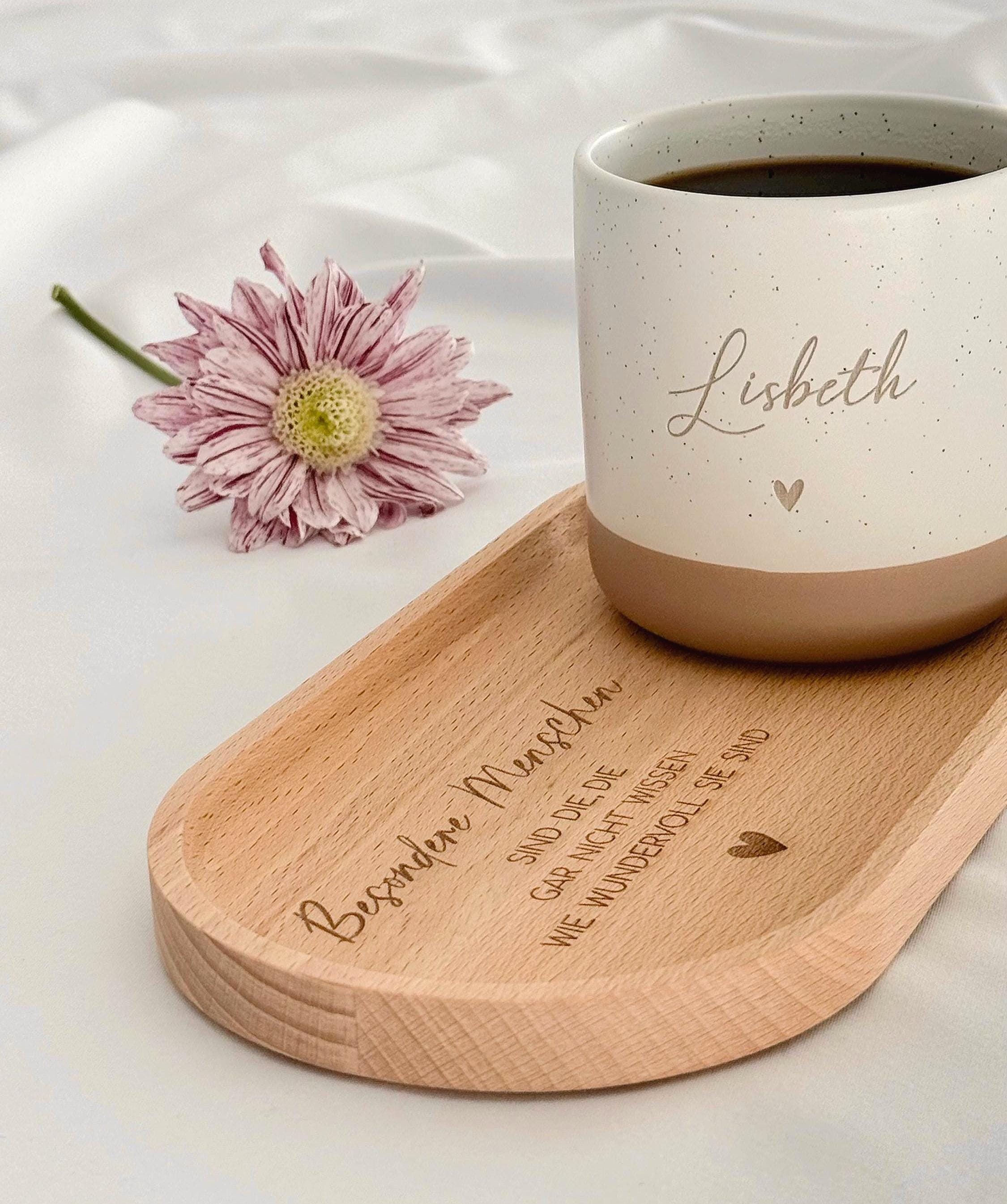 Personalisierte Tasse mit Namen auf Holztablett, liebevoll dekoriert mit Schleifenband und Blume. Geschenkidee für Freundschaft, Familie oder zum Abschied. Ideal für Geburtstage, Weihnachten, Nikolaus oder Ostern. Rustikaler Stil in warmen Beige-Tönen, ein echter Blickfang im Alltag. Geschenkset für Kaffee- und Teeliebhaber:innen mit individueller Gravur und natürlicher Ästhetik. Steingut Tasse beige Personalisierbar