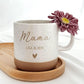Keramiktasse Set mit personalisierter Gravur – Mama-Tasse mit Kindername und Herz auf mattem Weiß-Beige. Spülmaschinenfest und hochwertig graviert. Dazu ein Buchenholztablett, lebensmittelecht behandelt, nur Handwäsche. Geschenkidee für Mama zu Muttertag, Geburtstag, Weihnachten oder Jubiläum. Persönliches Geschenkset für Frauen, das Eleganz und Bedeutung vereint.