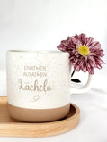 "Keramiktasse mit personalisierter Namensgravur, befüllt mit Kaffee – auf Tablett serviert. Beige Tasse mit matter Oberfläche und 360 ml Volumen, perfekt für den Start in den Tag. Geschenk für Kolleg:innen, Freund:innen oder Familie, ideal für Abschied oder als kleine Überraschung. Zeitloses Design, langlebig, spülmaschinengeeignet, liebevoll graviert und dekorativ. steingut tasse