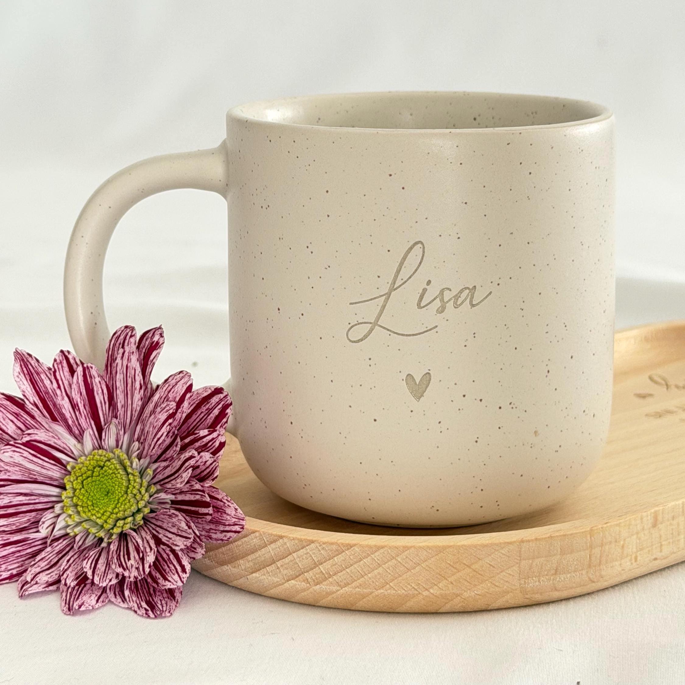 Obenansicht eines personalisierten Tassen-Sets: beige Keramiktasse mit Name auf graviertem Holztablett. Modernes, minimalistisches Design, perfekt als Geschenkidee für besondere Menschen. Steingut Tasse. Personalisierte Geschenke