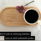 Obenansicht eines personalisierten Tassen-Sets: beige Keramiktasse mit Name auf graviertem Holztablett. Modernes, minimalistisches Design, perfekt als Geschenkidee für besondere Menschen.