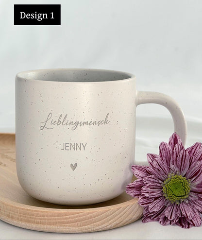 Detailaufnahme der personalisierten Tasse mit individueller Namensgravur. Weiße Keramiktasse mit gesprenkeltem Muster, matter Oberfläche und unglasiertem Boden. Perfekt als Geschenk für Freundin, Kollegin oder als kleine Aufmerksamkeit für besondere Menschen – geeignet für Kaffee, Tee oder heiße Schokolade. Mikrowellen- und spülmaschinenfest. Stilvoll und liebevoll gestaltet.Steingut Tasse . Geschenk für Herzensmensch und Lieblingsmensch