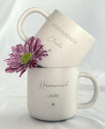 Keramiktasse mit Namensgravur auf Tablett, serviert auf einem gedeckten Frühstückstisch. Passend für den Alltag oder als besonderes Geschenk zu Feierlichkeiten. Für Familie, Freund:innen oder Kolleg:innen. Beige Tasse mit natürlichem Look, kombiniert mit geöltem Holztablett – personalisiert, langlebig, stilvoll und funktional. Kleine Geste mit großer Wirkung. Steingut Tasse . Geschenk für Herzensmensch und Lieblingsmensch