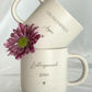 Personalisierte Tasse mit Namen auf Holztablett, liebevoll dekoriert mit Schleifenband und Blume. Geschenkidee für Freundschaft, Familie oder zum Abschied. Ideal für Geburtstage, Weihnachten, Nikolaus oder Ostern. Rustikaler Stil in warmen Beige-Tönen, ein echter Blickfang im Alltag. Geschenkset für Kaffee- und Teeliebhaber:innen mit individueller Gravur und natürlicher Ästhetik. Steingut Tasse . Geschenk für Herzensmensch und Lieblingsmensch
