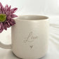 Nahaufnahme einer personalisierten Keramiktasse mit Namensgravur. Elegantes mattes Beige, feine Sprenkel, 360 ml. Ideal für Kaffee, Tee oder heiße Schokolade. Individuelles Geschenk für Freundin, Familie oder Kollegin. Steingut Tasse. Personalisierte Geschenke