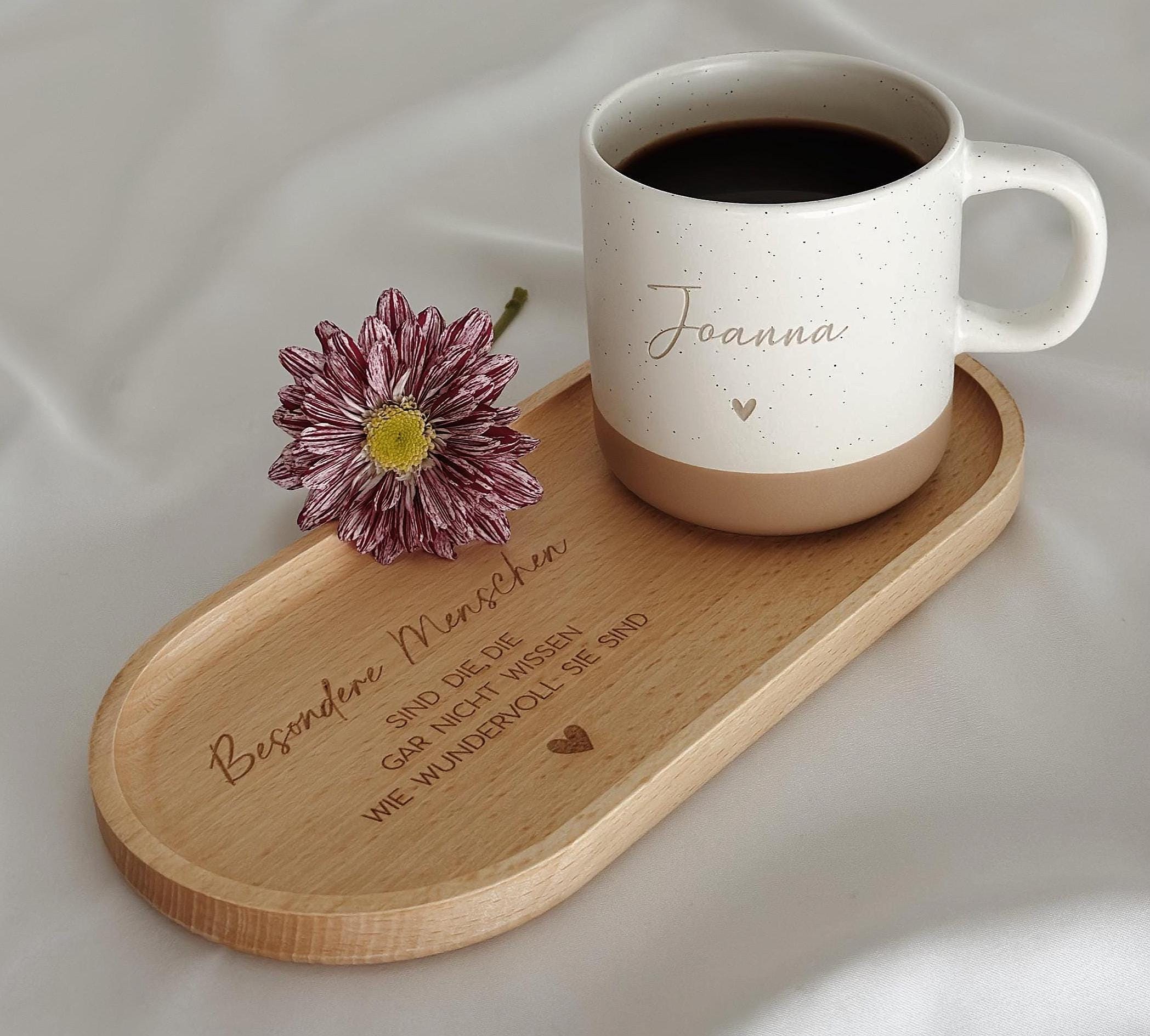 Keramiktasse mit personalisierter Namensgravur, befüllt mit Kaffee – auf Tablett serviert. Beige Tasse mit matter Oberfläche und 360 ml Volumen, perfekt für den Start in den Tag. Geschenk für Kolleg:innen, Freund:innen oder Familie, ideal für Abschied oder als kleine Überraschung. Zeitloses Design, langlebig, spülmaschinengeeignet, liebevoll graviert und dekorativ. Steingut Tasse. Personalisierte Geschenke