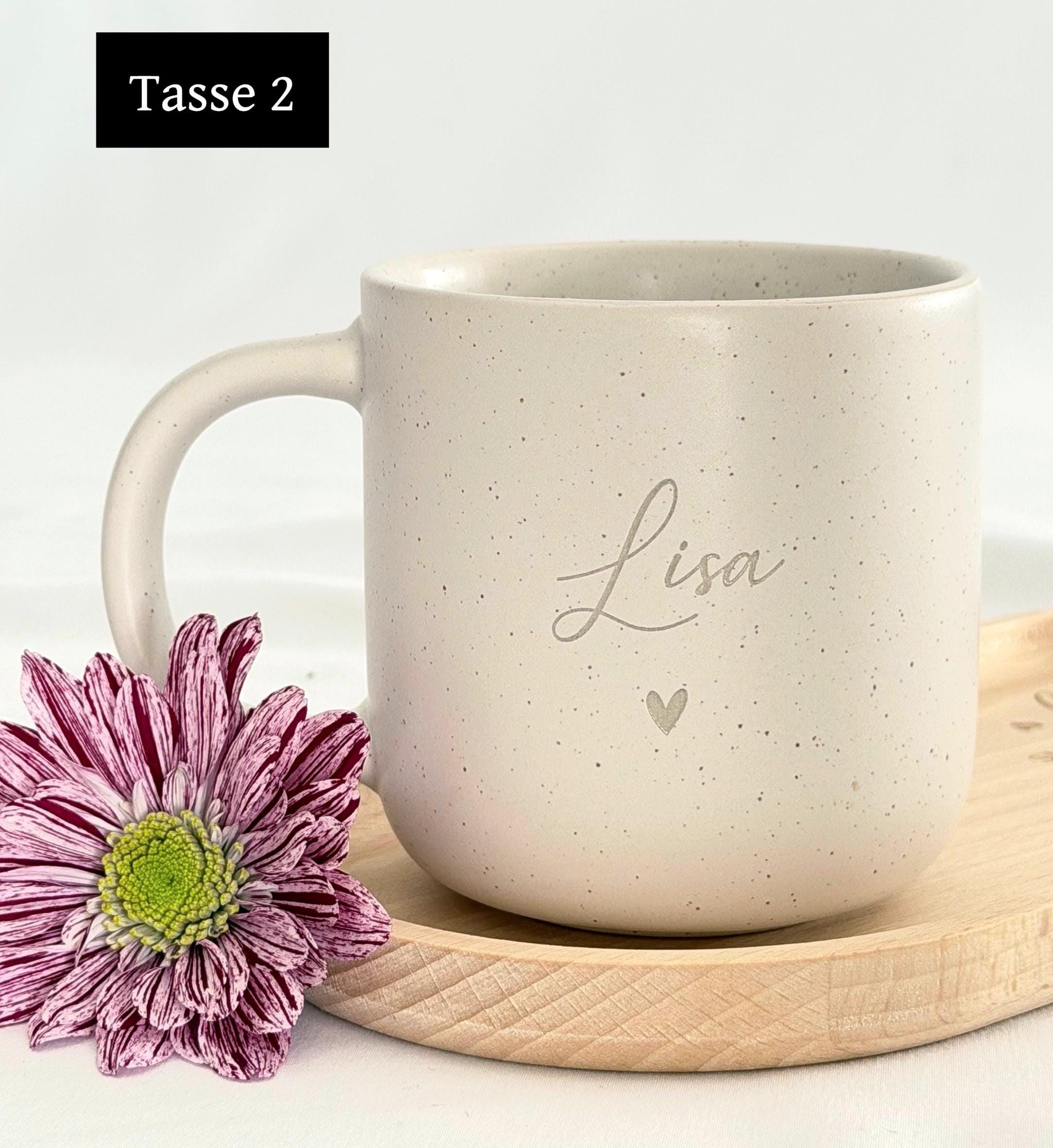 Nahaufnahme einer personalisierten Keramiktasse mit Namensgravur. Elegantes mattes Beige, feine Sprenkel, 360 ml. Ideal für Kaffee, Tee oder heiße Schokolade. Individuelles Geschenk für Freundin, Familie oder Kollegin. Steingut Tasse beige Personalisierbar