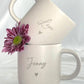 Set aus personalisierter Tasse und Tablett aus verschiedenen Blickwinkeln gezeigt. Perfekt für Produktpräsentation im Shop. Geschenkidee für Geburtstag, Weihnachten oder Freundschaft. Tasse mit unglasierter Unterseite und dezenter Gravur, Tablett aus Buchenholz mit schöner Maserung. Ideal für Menschen, die das Besondere lieben. Steingut Tasse beige Personalisierbar