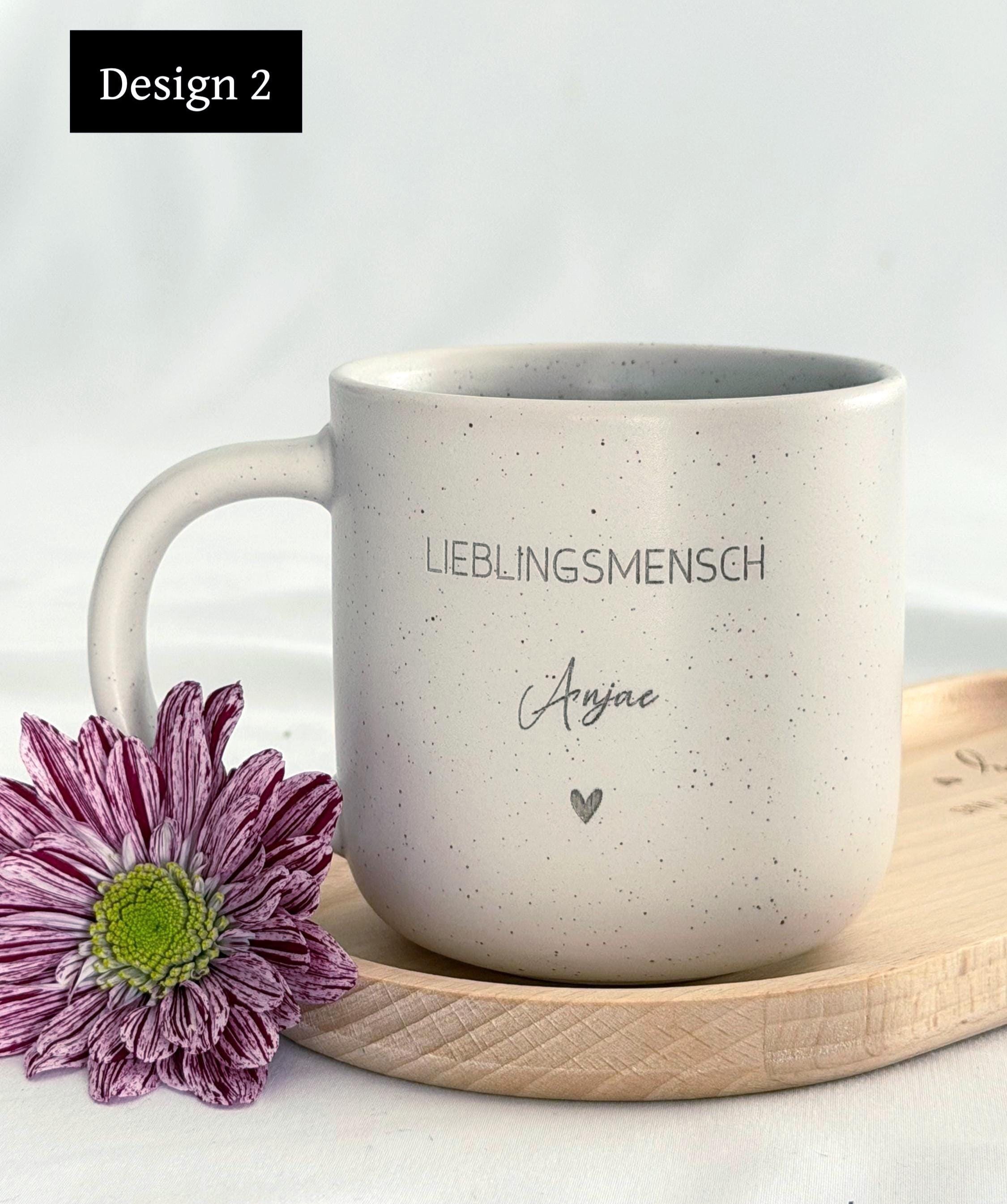 Detailaufnahme der personalisierten Tasse mit individueller Namensgravur. Weiße Keramiktasse mit gesprenkeltem Muster, matter Oberfläche und unglasiertem Boden. Perfekt als Geschenk für Freundin, Kollegin oder als kleine Aufmerksamkeit für besondere Menschen – geeignet für Kaffee, Tee oder heiße Schokolade. Mikrowellen- und spülmaschinenfest. Stilvoll und liebevoll gestaltet.Steingut Tasse . Geschenk für Herzensmensch und Lieblingsmensch