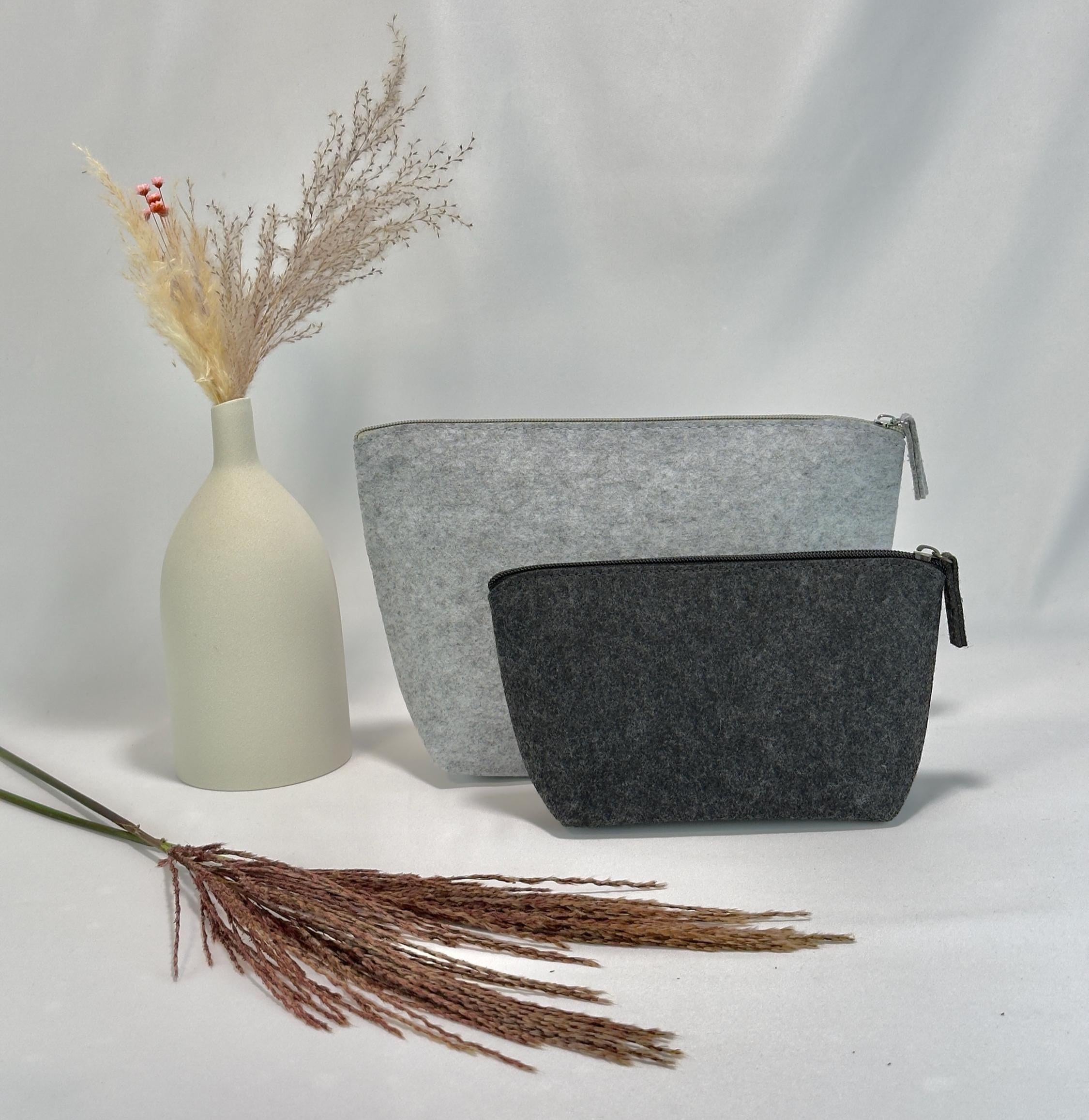 Kosmetiktasche mit Name personalisiert, ideal als Geschenk für Tochter oder beste Freundin, dekorativ platziert neben Parfum, Make-up und kleinen Accessoires auf einem Holzuntergrund.