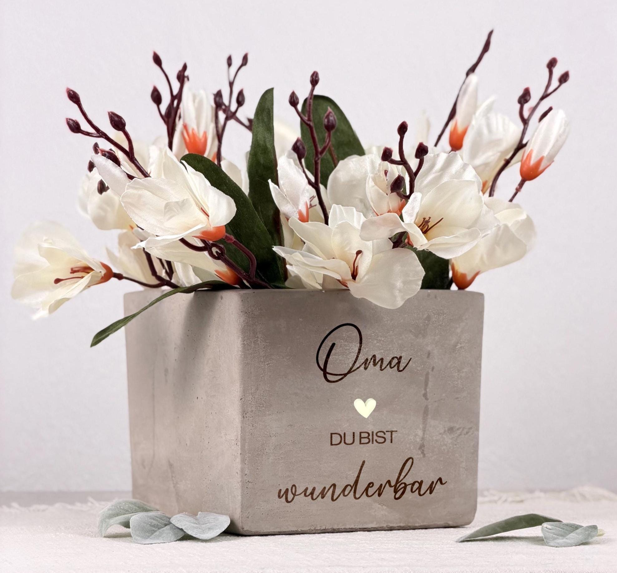 Personalisierter Blumentopf mit liebevoller Gravur als Geschenk für Mama oder Oma. Perfekt für Weihnachten, den 60. Geburtstag oder Muttertag. Zeigt hochwertige Keramik in Betonoptik mit individuellem Spruch „Danke Mama“ oder „Danke Oma“. Ideal als dekorativer Blumentopf für kleine Pflanzen, Kräuter oder Blüten. Ein emotionales, persönliches Geschenk für besondere Frauen.
