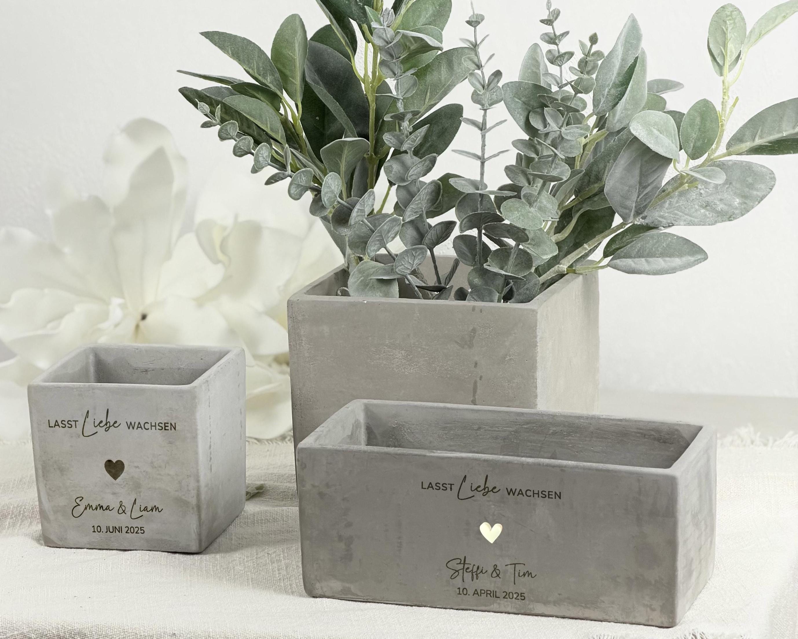 Eleganter Blumentopf mit Gravur, personalisierbar mit Namen des Brautpaares. Perfektes Hochzeits- oder Verlobungsgeschenk, das sich ideal als Geldgeschenk oder dekoratives Element eignet. Eine stilvolle Geschenkidee für Paare, die gemeinsame Erinnerungen und besondere Momente festhält.