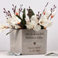 Ein personalisierter Blumentopf mit graviertem Namen des Brautpaars, gestaltet als besonderes Hochzeitsgeschenk. Der Topf zeigt eine elegante Oberfläche, einen warmen Naturton und eine liebevolle Gravur mit Herzen und Datum. Eine kleine Pflanze sitzt dekorativ im Inneren. Ideal als Geldgeschenk-Idee oder Einweihungsgeschenk, perfekt für Paare, die ein stilvolles und persönliches Dekostück für ihr neues Zuhause suchen.