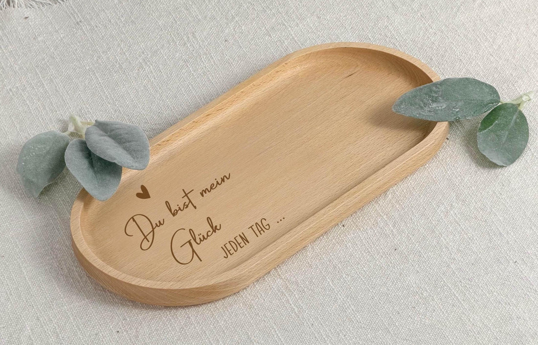 Personalisiertes Holztablett mit der Gravur „Du bist mein Glück“, liebevoll verarbeitet aus hochwertigem Holz. Das Tablett liegt auf einem hellen Untergrund und zeigt eine klare, saubere Gravur mit emotionaler Botschaft. Ideal als Kaffeetablett, Frühstückstablett oder dekoratives Wohnaccessoire. Dieses Holztablett eignet sich perfekt als Geschenk für Frauen, Freundinnen, Mütter oder Schwestern zu besonderen Anlässen wie Geburtstag, Muttertag, Weihnachten oder Valentinstag.