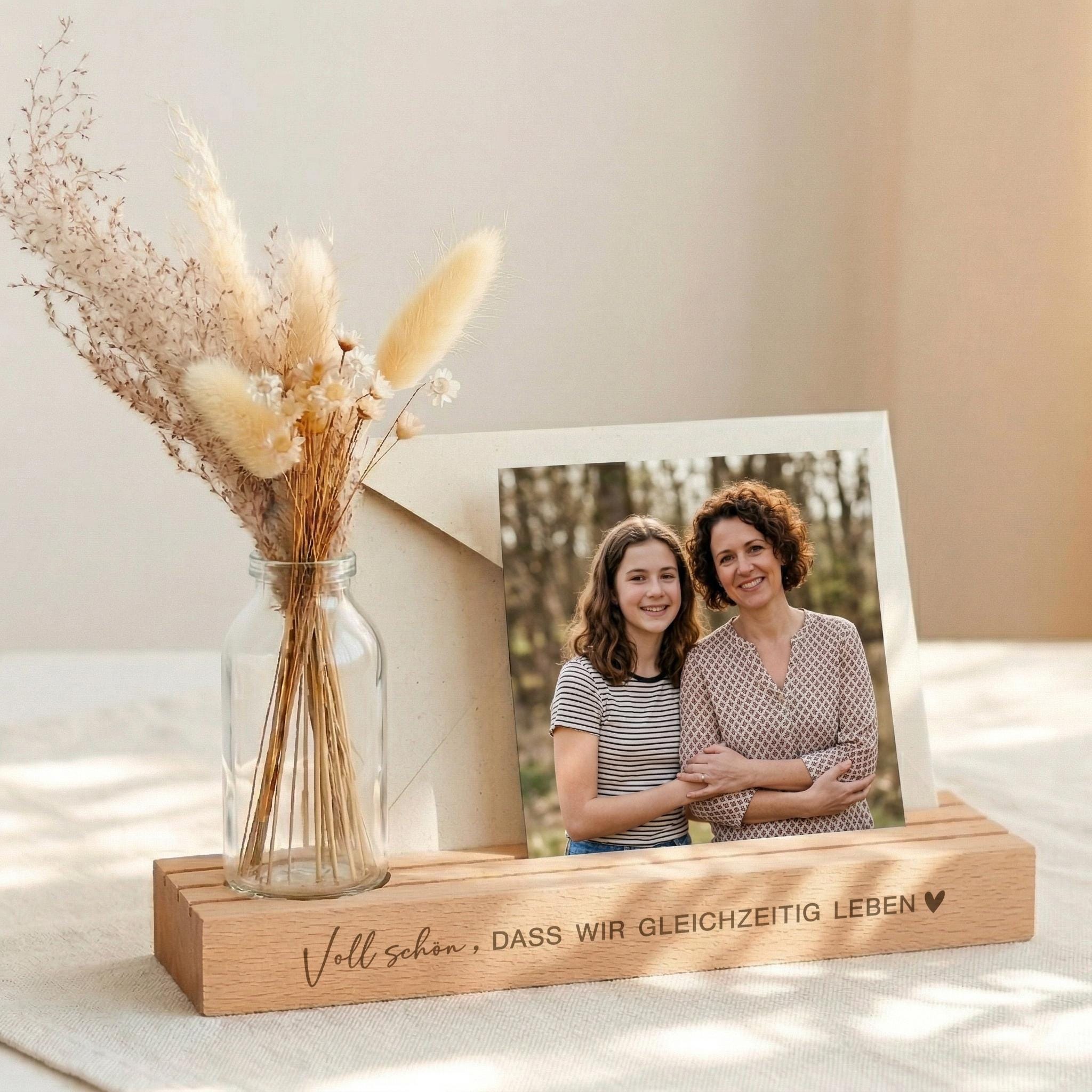 Kartenhalter personalisiert als Fotohalter mit Vase und Trockenblumen. Die Bilderleiste aus Buchenholz mit Spruch eignet sich als Geschenk beste Freundin oder Geschenk Schwester. Kartenständer mit Gravur für Fotos und Erinnerungen. Fotoständer personalisiert ideal als Tischdeko Geburtstag oder Geburtstagsgeschenk Frau. Perfekt als personalisiertes Geschenk Frau oder Geschenk Geburtstag für sie.