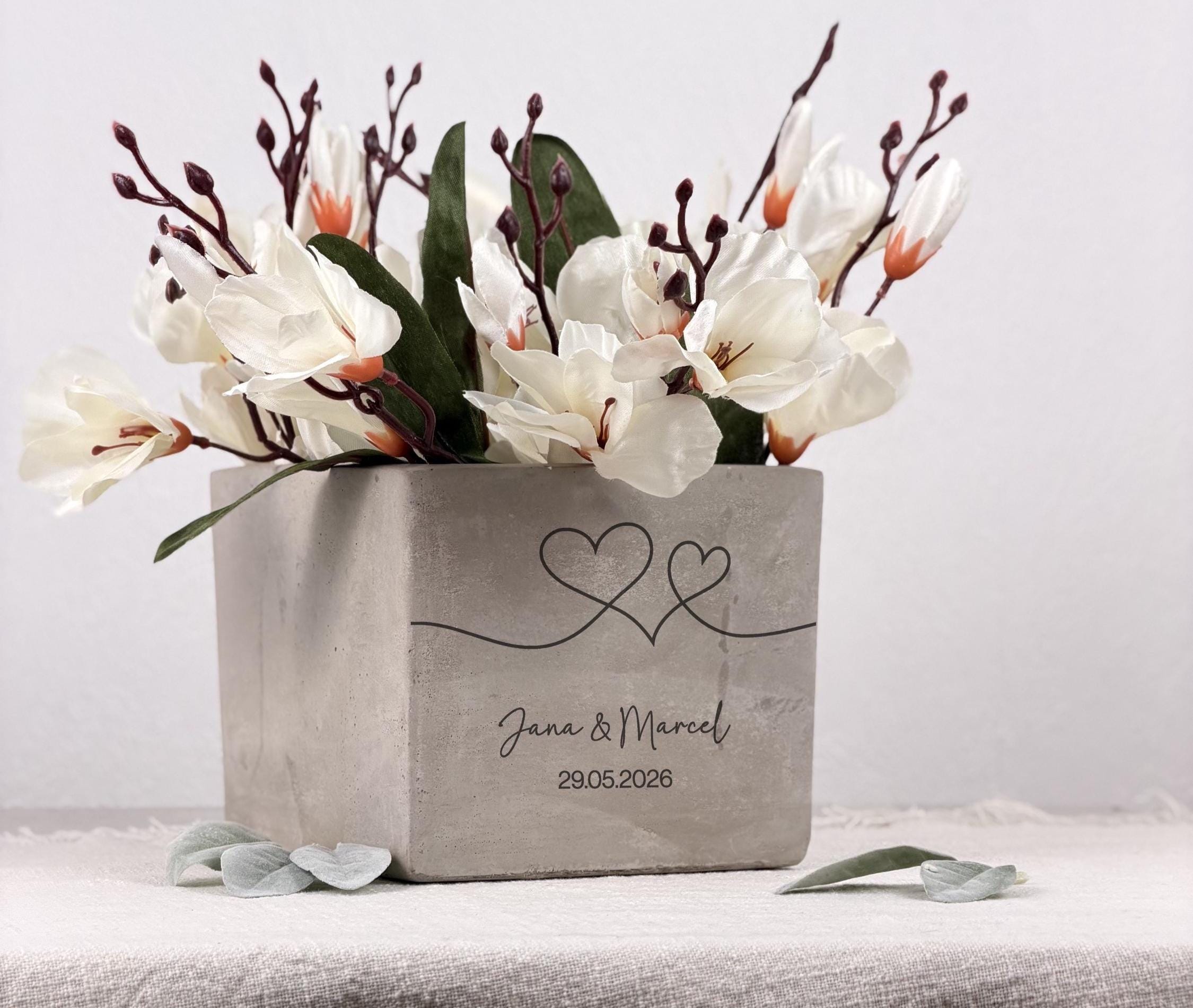 Hochzeitsgeschenk mit Namen als stilvoller Blumentopf in hochwertiger Betonoptik. Dieses personalisierte Geschenk für Braut und Bräutigam eignet sich ideal für Blumen, Kräuter oder kleine Pflanzen und bringt eine persönliche und emotionale Note in jedes Zuhause.