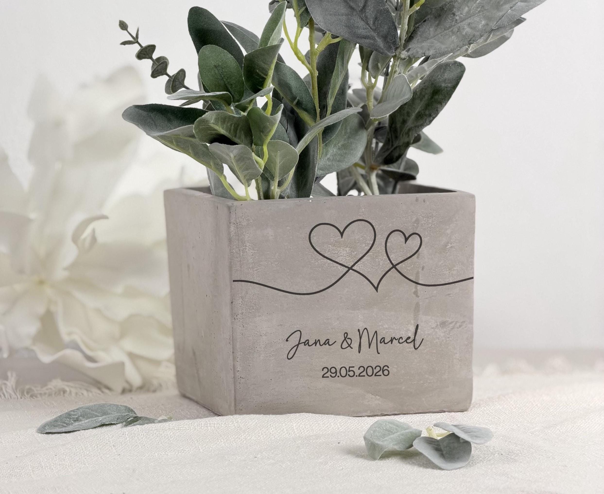 Blumentopf personalisiert mit Gravur als Geschenkidee zur Hochzeit oder Verlobung. Das hochwertige Design in Betonoptik macht dieses Geschenk zu einem stilvollen Highlight mit persönlicher Botschaft und bleibendem Erinnerungswert.