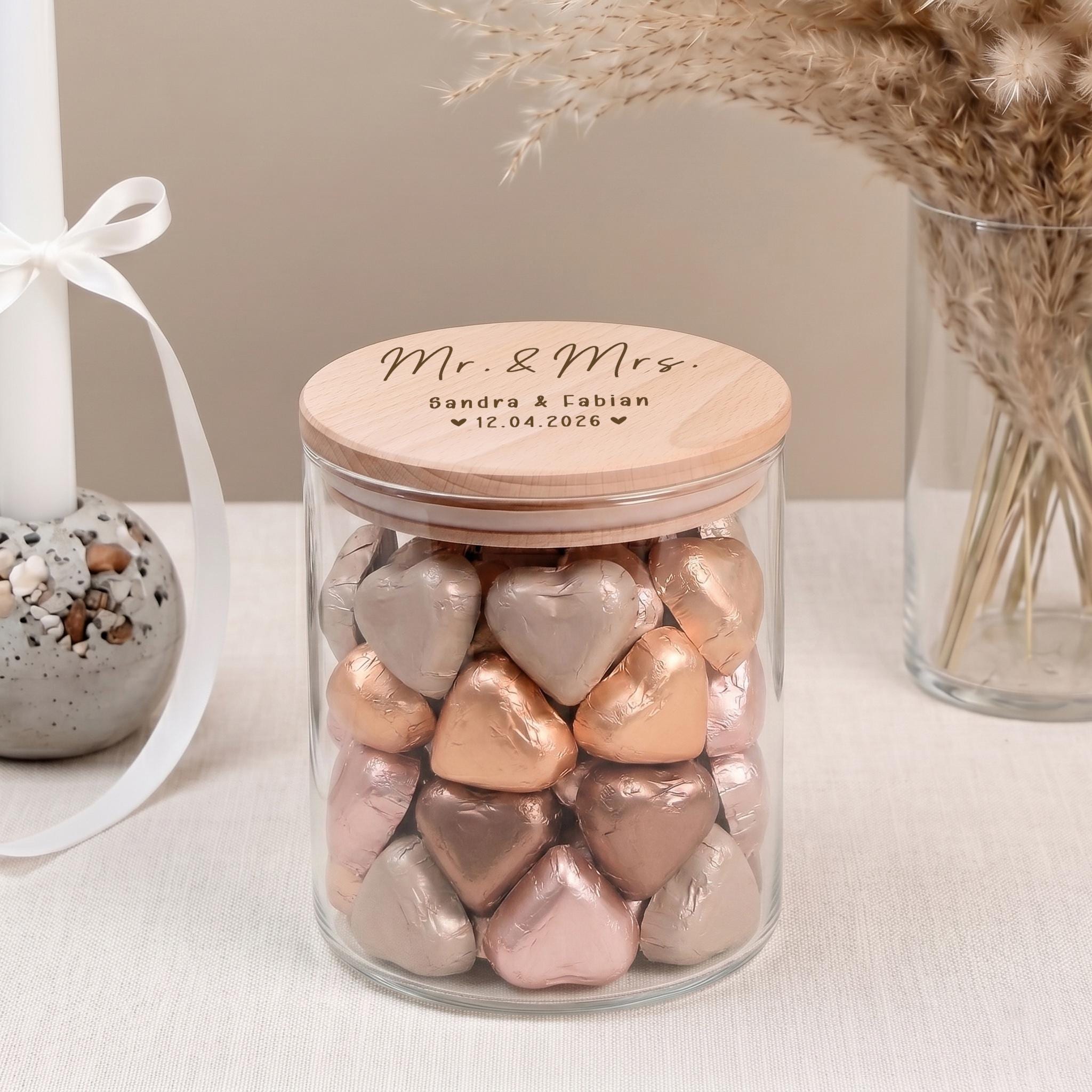 Personalisiertes Vorratsglas als Geldgeschenk zur Hochzeit für Brautpaar oder Ehepaar. Das dekorative Glas mit individueller Gravur eignet sich perfekt zum stilvollen Verschenken von Geld, Gutscheinen oder kleinen Überraschungen zur Hochzeit oder Verlobung.