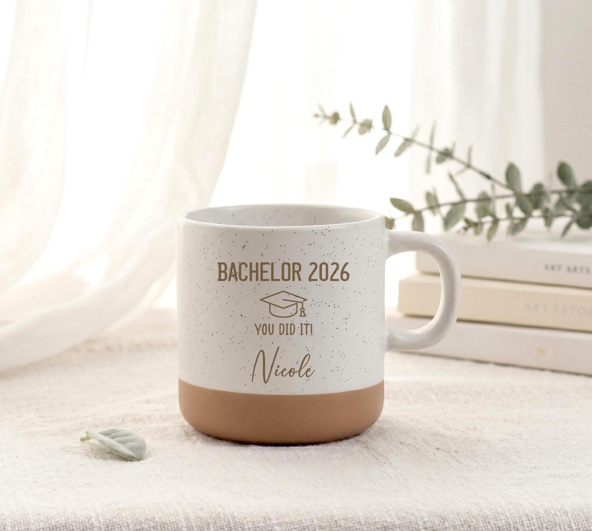 Personalisierte Kaffeetasse mit hochwertiger Lasergravur und individuellem Wunschnamen als besonderes Geschenk zum Bachelorabschluss, Studienabschluss oder zur bestandenen Prüfung – eine persönliche Erinnerung für Absolventinnen und Absolventen.